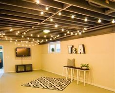 an empty room with lights on the ceiling and a black and white rug in front of it