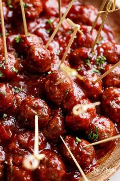 several skewered meatballs in a bowl with toothpicks sticking out of them