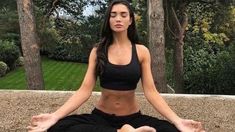 a woman sitting in the middle of a yoga pose