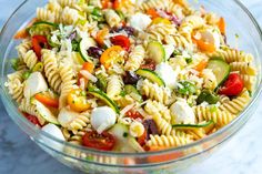 a bowl filled with pasta salad on top of a table