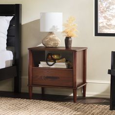 a night stand with two drawers and a lamp on the side table next to it