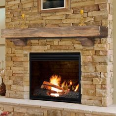 a stone fireplace with logs burning in it