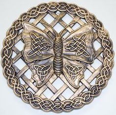 an intricately designed metal belt buckle with two butterflies on the center, and celtic knot work