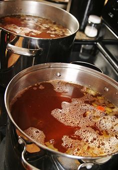 two pans filled with soup sitting on top of a stove next to each other