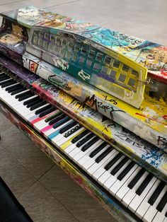 an old piano is covered with graffiti and has been placed on top of it for display