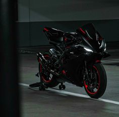 a black motorcycle with red lights on it's front tire is parked in a parking lot