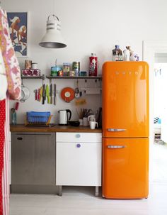 an orange refrigerator sitting in the middle of a kitchen