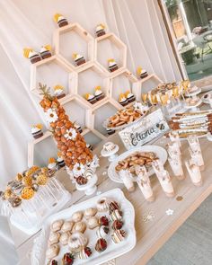 an assortment of desserts and pastries are displayed on a table with honeycombs