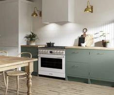 a white stove top oven sitting inside of a kitchen next to a wooden dining table