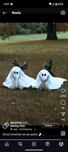 two ghost dolls are laying in the grass