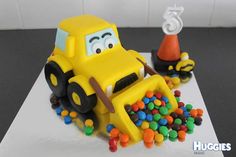 a cake made to look like a construction vehicle with lots of candy on the side