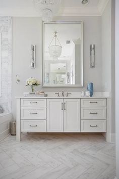 a white bathroom with two sinks and a large mirror on the wall over it's vanity