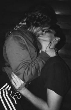 black and white photograph of two people kissing each other