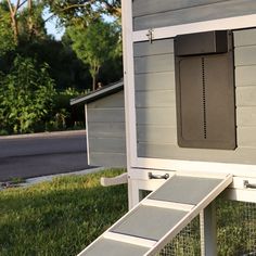 a chicken coop with the door open and a ramp attached to it's side