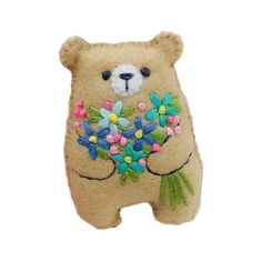 a teddy bear with flowers on it's chest