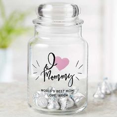 a glass jar filled with chocolates on top of a table