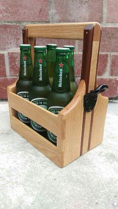 a wooden case with six bottles in it on the ground next to a brick wall