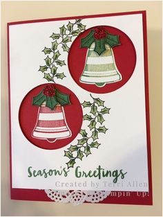 a christmas card with two bells and holly wreaths on the front, in red and white