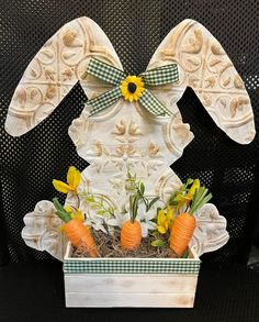 an easter decoration with carrots and daffodils