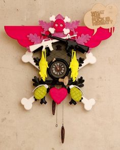 a cuckoo clock is decorated with pink, yellow and green decorations