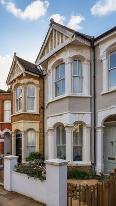 a row of houses with white trim and windows