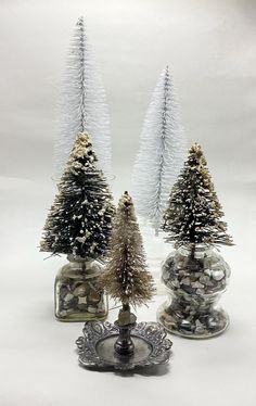 three small christmas trees in glass vases