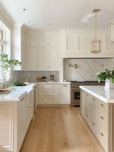 a kitchen with white cabinets and wood floors