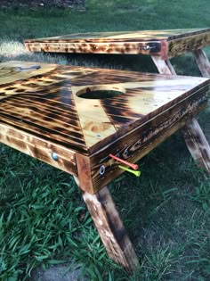 two wooden tables sitting on top of grass