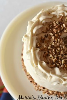 a cake with white frosting and nuts on top