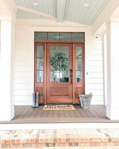 a front porch with a door and potted plant