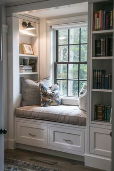 a window seat in the corner of a room with bookshelves on either side