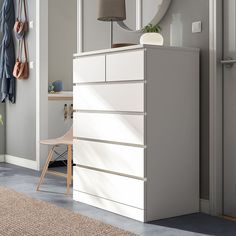 a white dresser sitting next to a window