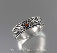 a silver ring with red stones on it