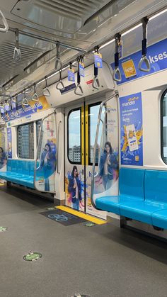 the inside of a subway train with blue seats and advertisements on it's doors