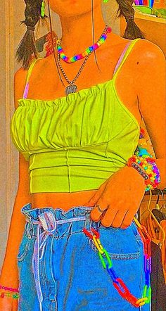 a girl with her hands in her pockets wearing colorful bracelets and a neon top