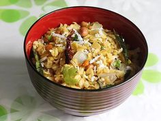 a red bowl filled with rice and vegetables