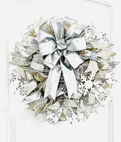 a christmas wreath with silver ribbons and snowflakes