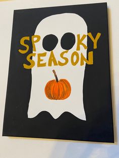 a sign that says spooky season with a pumpkin in the front and an image of a ghost behind it