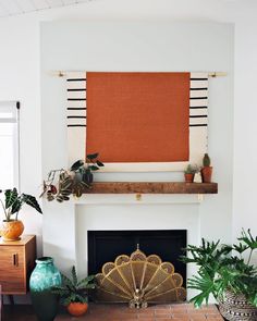 a living room filled with furniture and a fire place covered in an orange piece of art