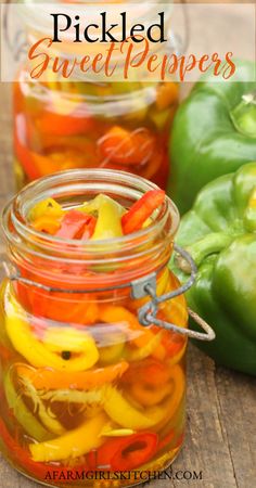 jars filled with pickled sweet peppers sitting on top of a wooden table next to green peppers