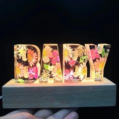 the word baby spelled with flowers is lit up