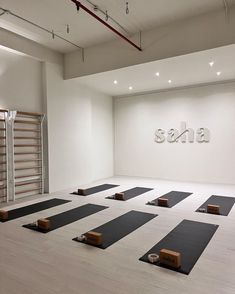 yoga mats are lined up on the floor in front of a wall that reads sauna