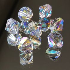 several different sized diamonds sitting on top of a black surface with one diamond in the middle