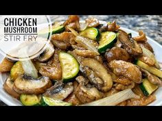 chicken mushroom stir fry with zucchini and onions on a white plate over granite countertop