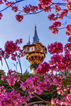 the tower is surrounded by pink flowers and trees