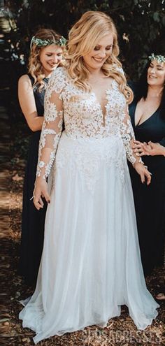 two women in black dresses standing next to each other and one woman wearing a white dress