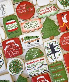 decorated christmas cookies are arranged on a table with holiday sayings and decorations around them