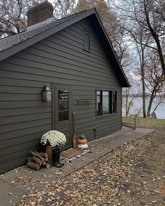 there is a house with a tree in the front yard and flowers on the porch