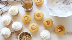 cupcakes with white frosting and caramel toppings next to a jar of peanut butter