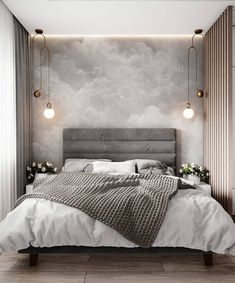 a large bed sitting under two lights in a bedroom next to a wall with clouds on it